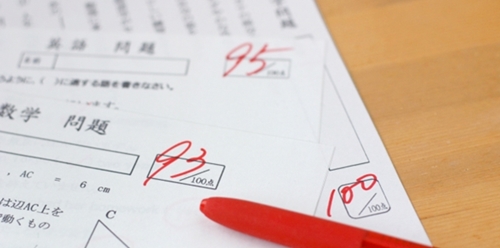 採点済みのテストの答案用紙と赤ペン